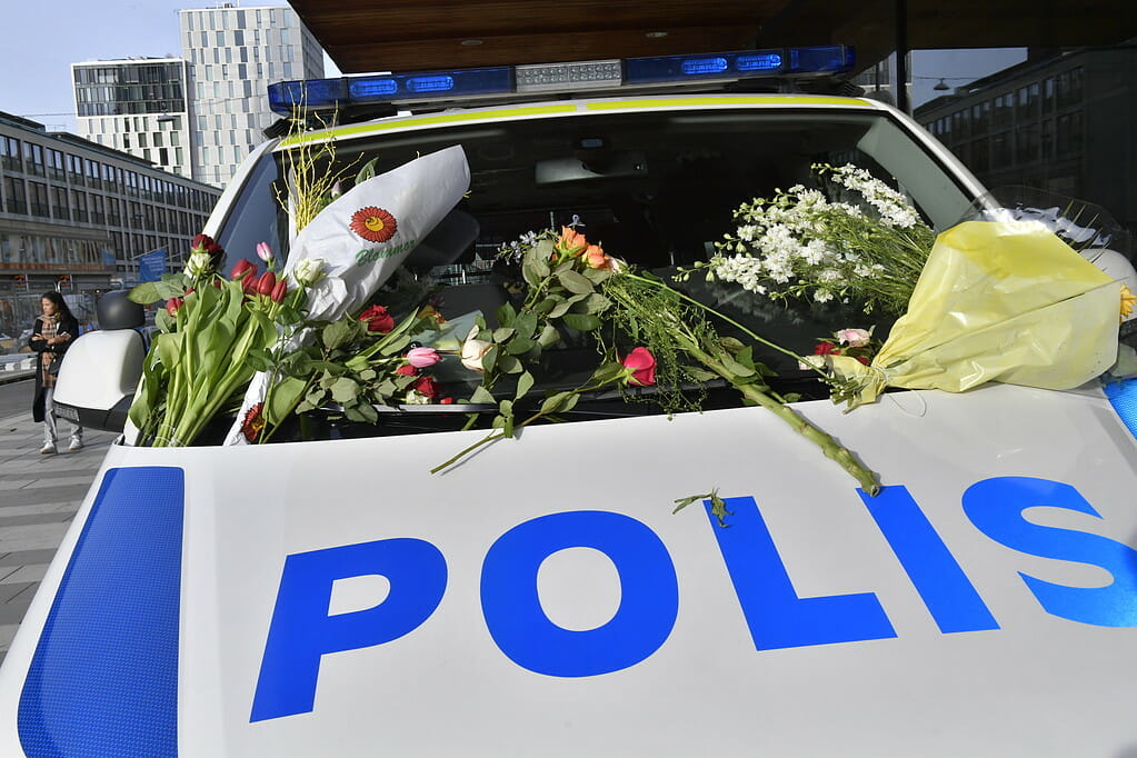STOCKHOLM 2017-04-09 Blommor på en polisbil. Människor samlas och lämnar blommor utanför Åhléns City i centrala Stockholm för att hedra offren för fredagens terrorattack på Drottninggatan. Det var i fredags som en man i en kapad lastbil körde på ett stort antal personer på Drottninggatan. Fyra personer dödades och 15 skadades. Foto: Jonas Ekströmer / TT