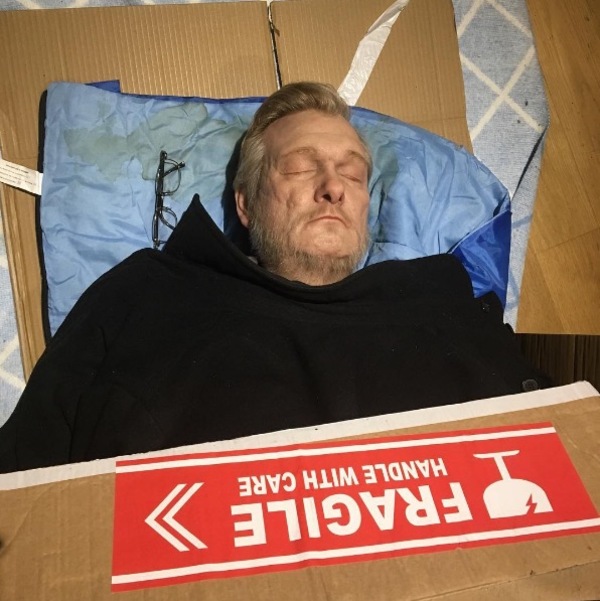 Zdjęcie przedstawia hiperrealistyczną rzeźbę bezdomnego mężczyzny