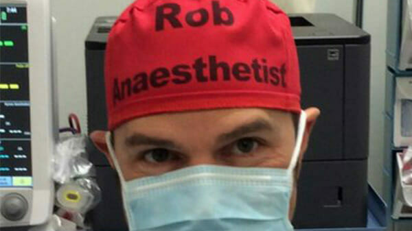 Na zdjęciu znajduje się doktor Rob, na którego czepku napisane jest jego imię i wykonywany zawód (anestezjolog)