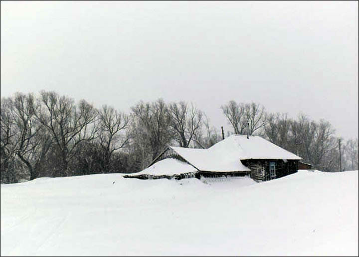 Na zdjęciu znajduje się zasypana śniegiem chata