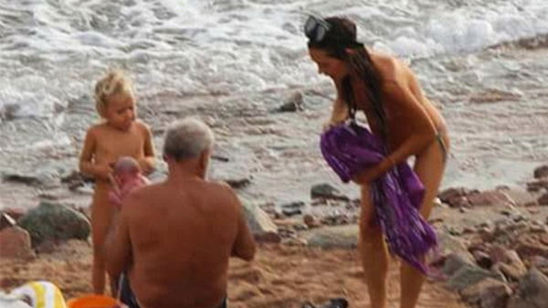 Na zdjęciu znajdują się wszystkie osoby biorące udział w porodzie - stoją i siedzą na plaży