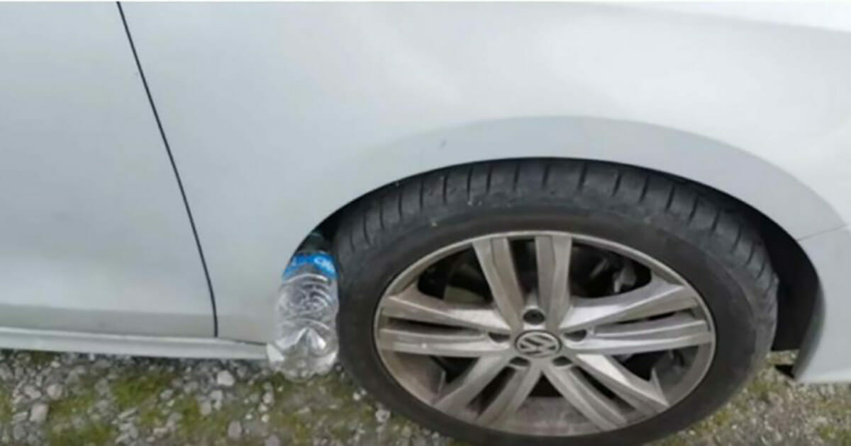 Plastikowa butelka wsadzona między koło a błotnik samochodu