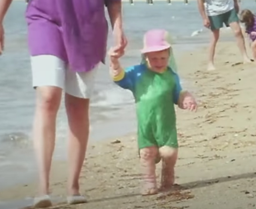 chore dziecko i dorosła osoba spacerują po plaży