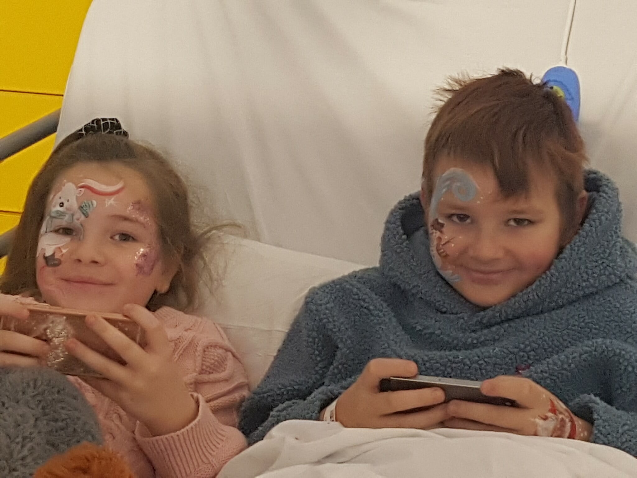 dzieci z pomalowanymi twarzami leżą w łóżku