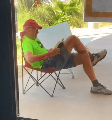 mężczyzna czyta książkę na leżaku