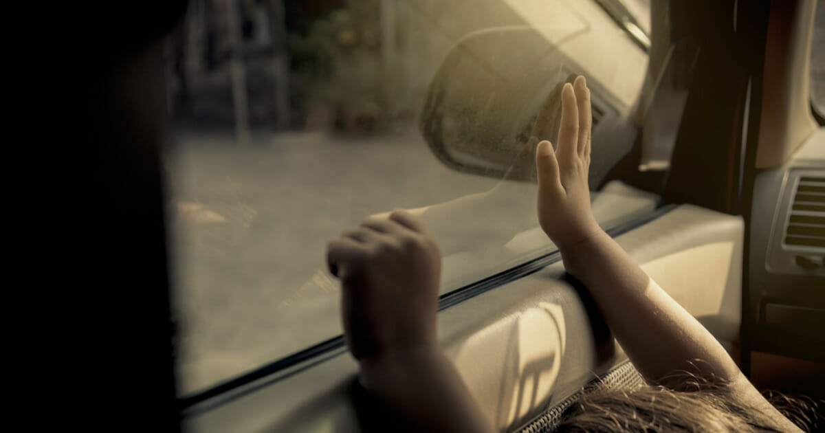 rączki dziecka dotykają od wewnątrz  okna samochodu