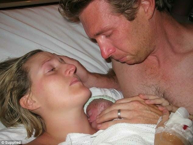 kobieta, mężczyzna i niemowlę leżą w łóżku