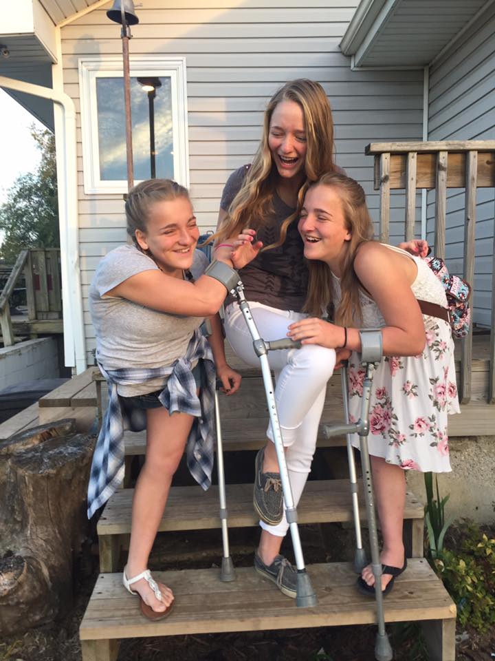 trzy dziewczyny śmieją się stojąc na schodach przed domem