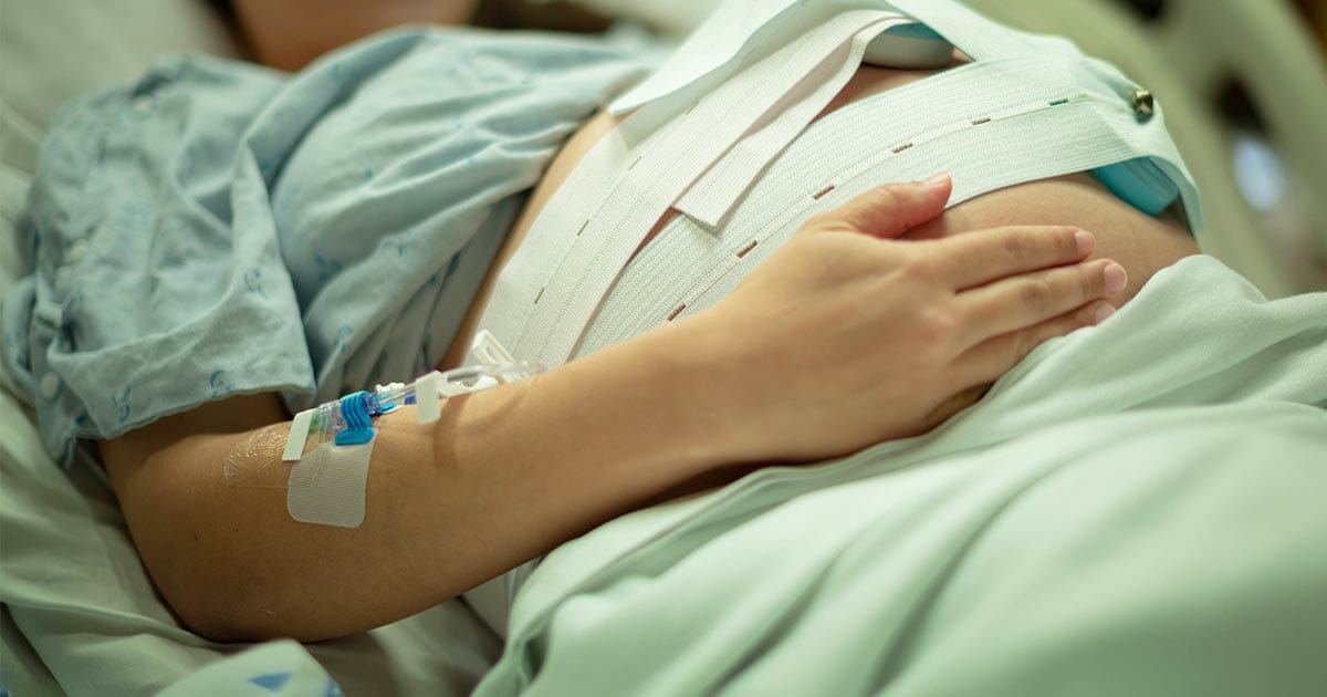 kobieta z ciążowym brzuchem leży w szpitalu